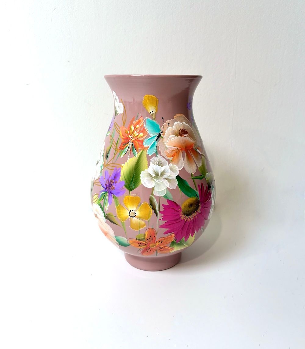 Een mauve keramische vaas met een taps toelopende hals, versierd met een levendig, handgeschilderd met kleurrijke bloemen.