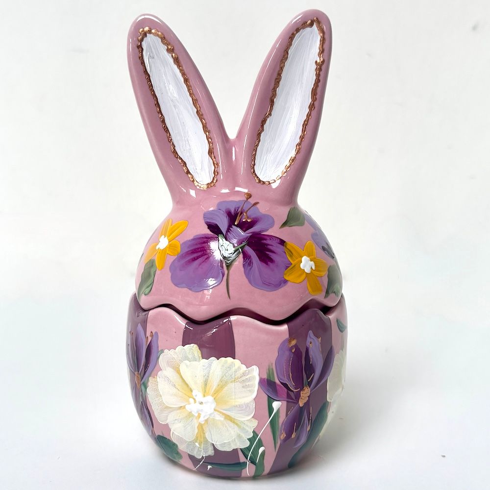 Roze keramische eierdop met bloemenmotief en bloempotje in de vorm van een konijntje op een witte achtergrond.