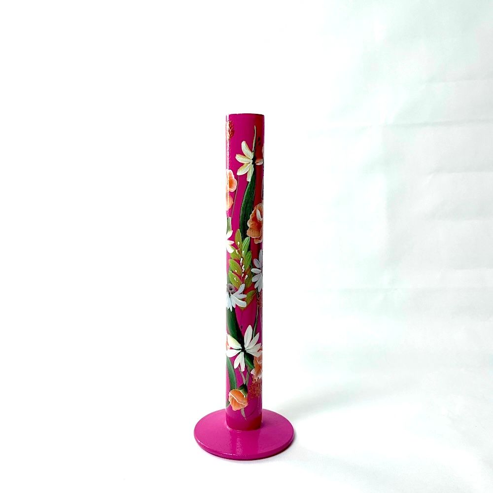 Een magenta, verticale keukenrolhouder versierd met witte en oranje bloemmotieven, geplaatst tegen een witte achtergrond.