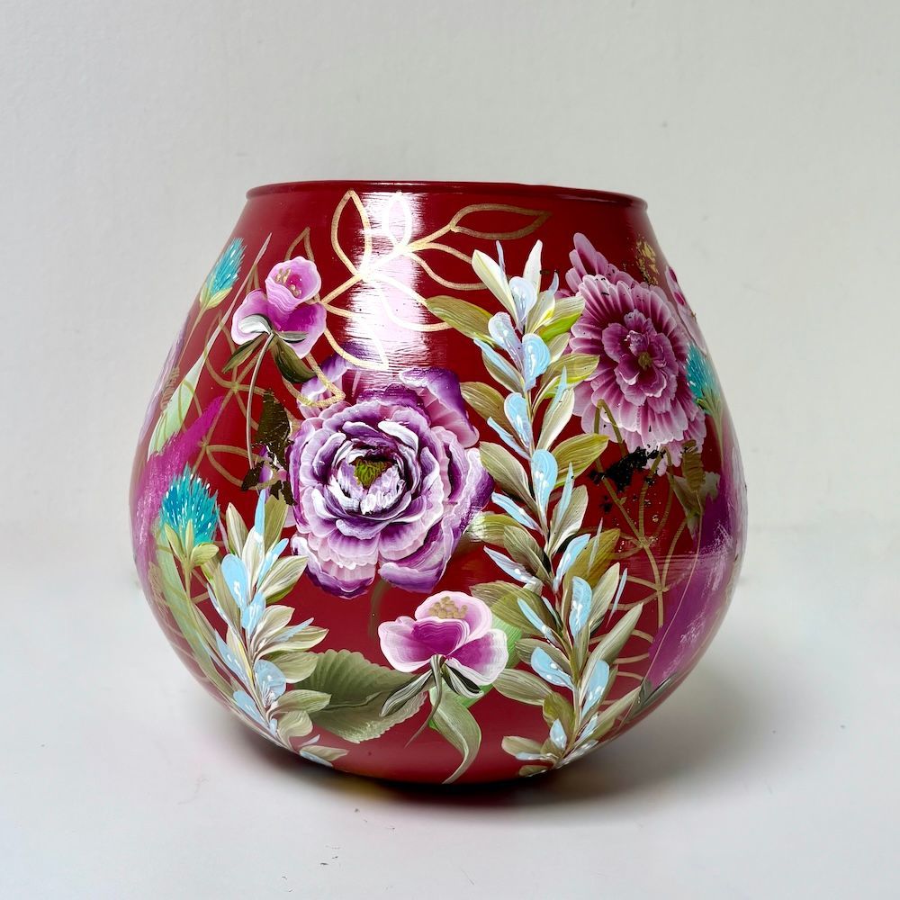 Rode vaas met bloemen en een kleurrijke kolibrie erop geschilderd.