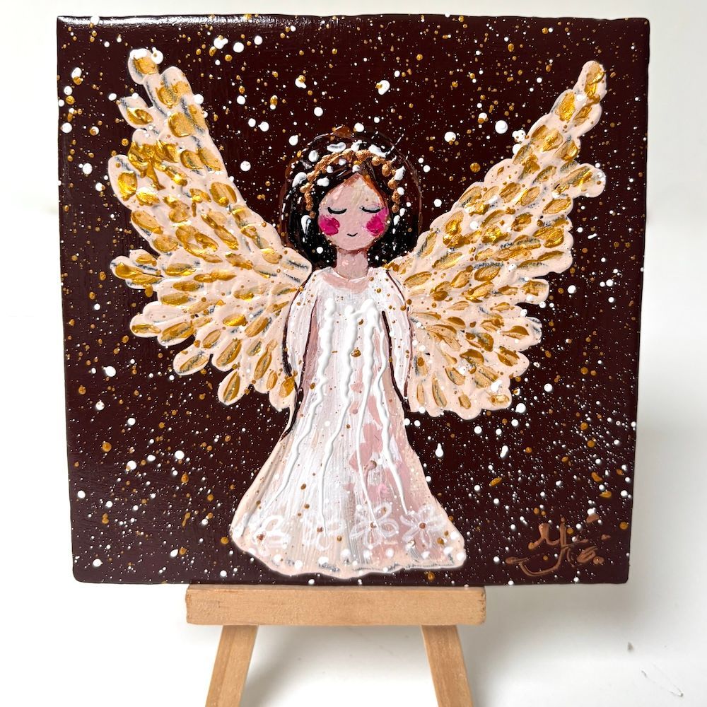 Engelenkunstwerk met gouden vleugels op een donkere, gespikkelde achtergrond, tentoongesteld op een kleine schildersezel.