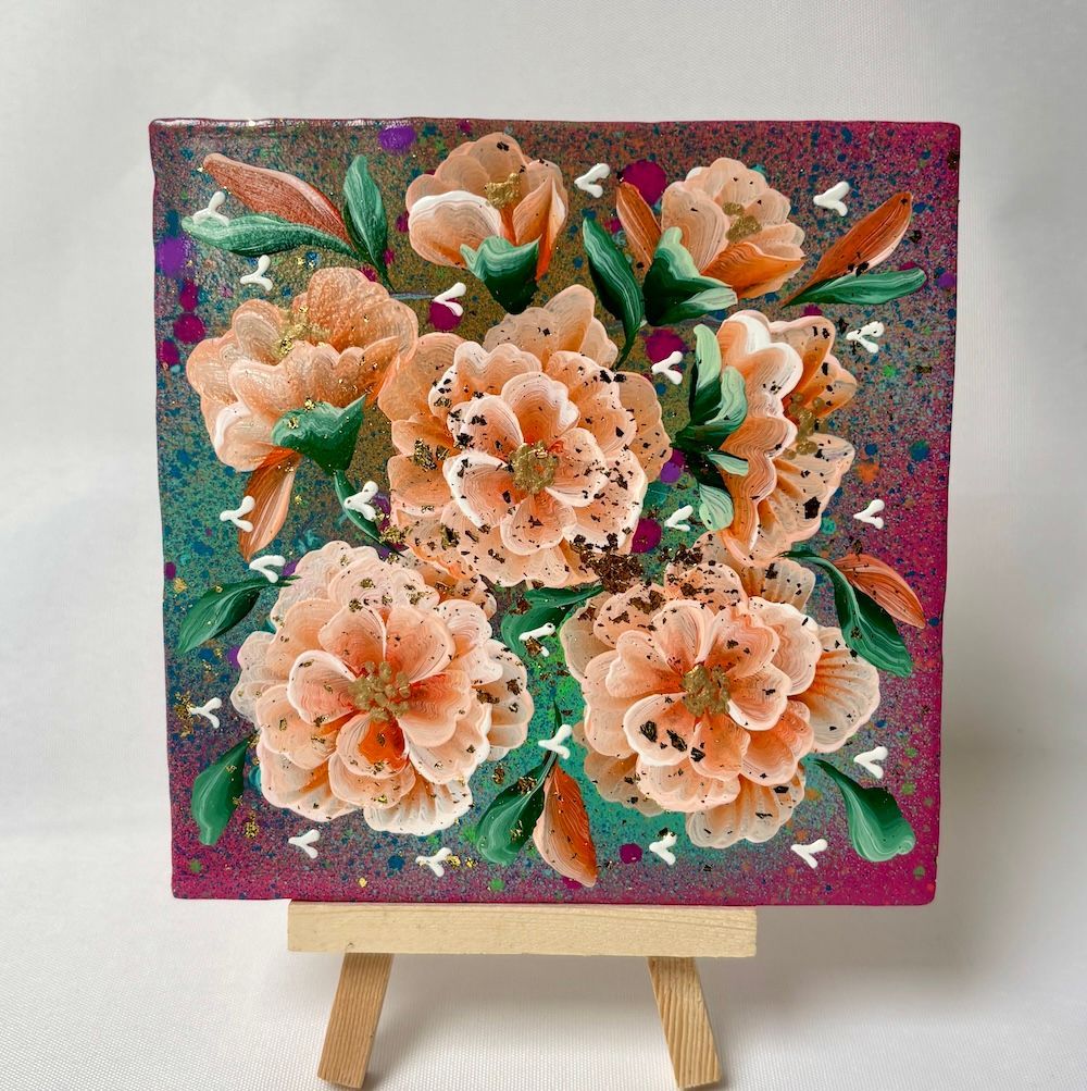 Een vierkant tegeltjej van perzikkleurige bloemen met groene bladeren op een gespikkelde magenta achtergrond