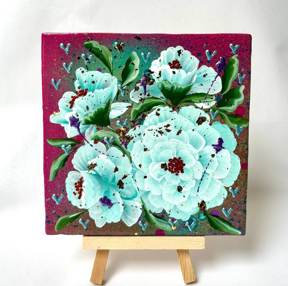 Een tegel met lichtblauwe bloemen met donkere centra, besprenkeld met bruin, op een magenta achtergrond op een schildersezel.