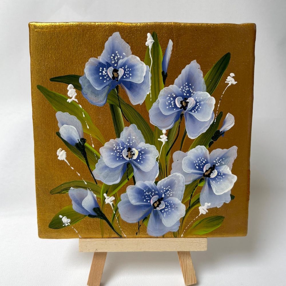 Een vierkant schilderij tegeltje met blauwe orchideeën met groene bladeren tegen een glinsterende gouden achtergrond