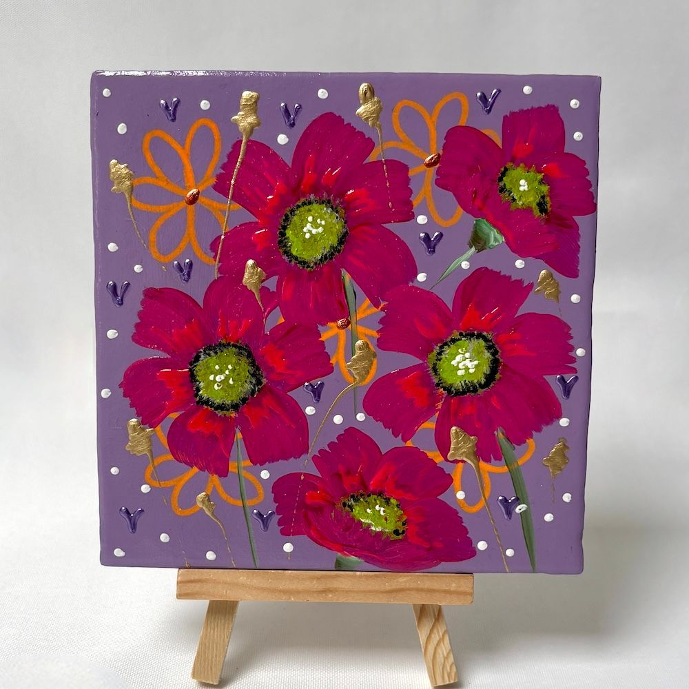 Paars canvas met vijf roze bloemen met groene centra op een kleine houten schildersezel.