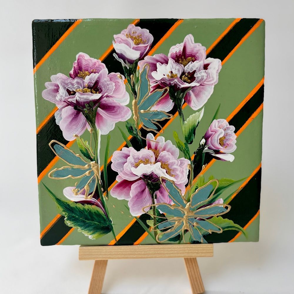 Bloemschilderij met roze bloemen op een groene achtergrond, tentoongesteld op een kleine schildersezel.