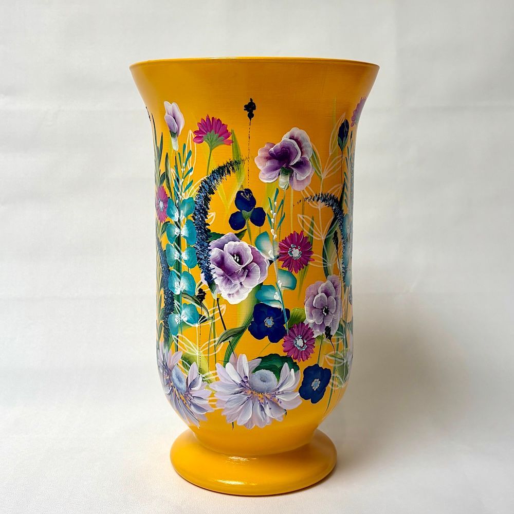 Een felgele decoratieve vaas, handbeschilderd met een ijsvogel in het midden, omringd door diverse kleurrijke bloemen.