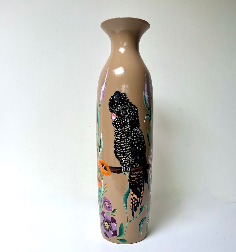 Hoge beige vaas met een zwart luipaard- en bloemenmotief op een witte achtergrond.