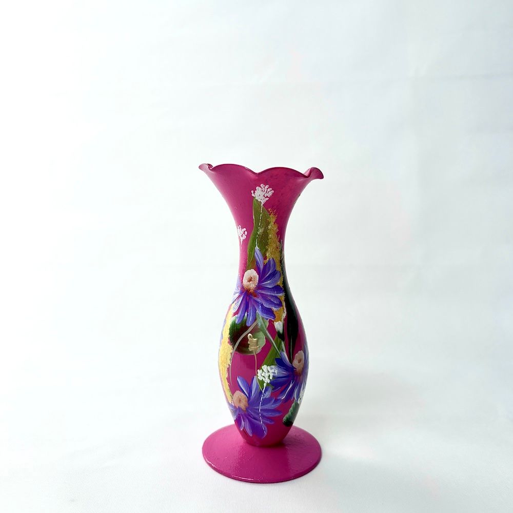 Een magenta vaas met een gegolfde bovenkant, versierd met handgeschilderde blauwe en gouden bloemmotieven