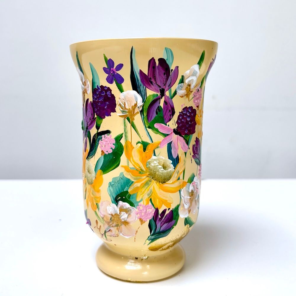 Handbeschilderde keramische vaas met paarse, gele en groene bloemen op een witte ondergrond