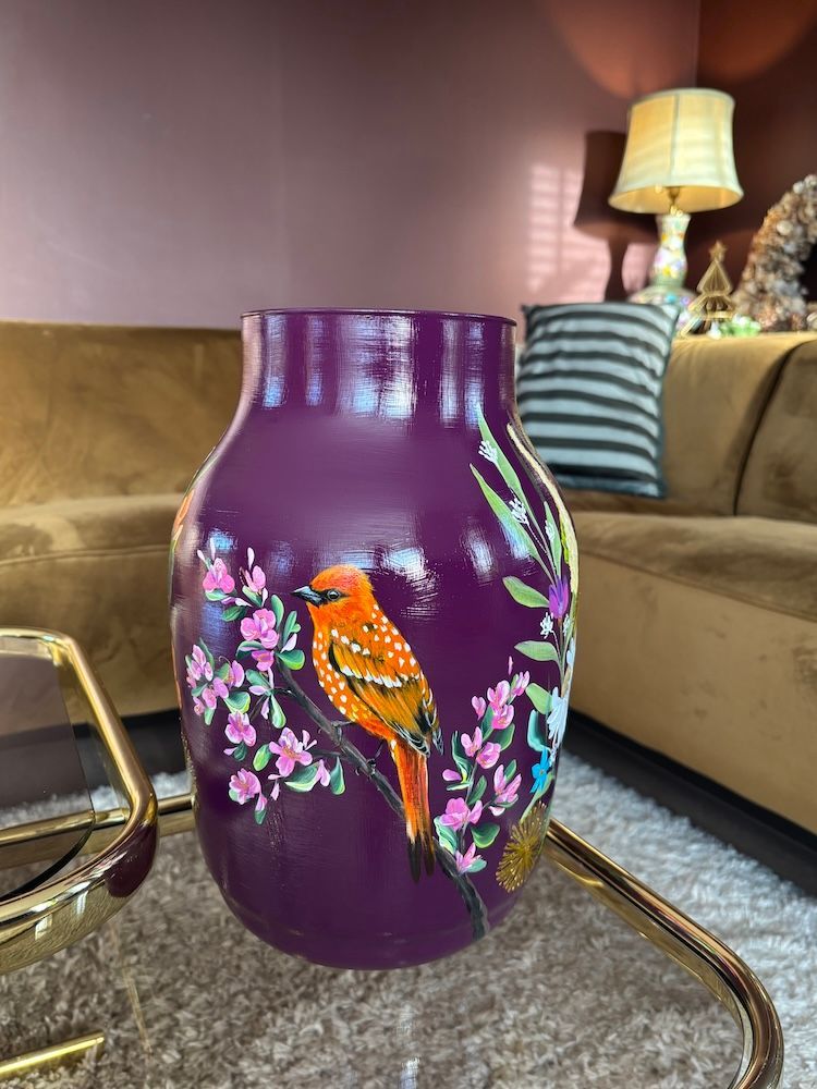 Paarse vaas met een beschilderde oranje vogel en roze bloesems