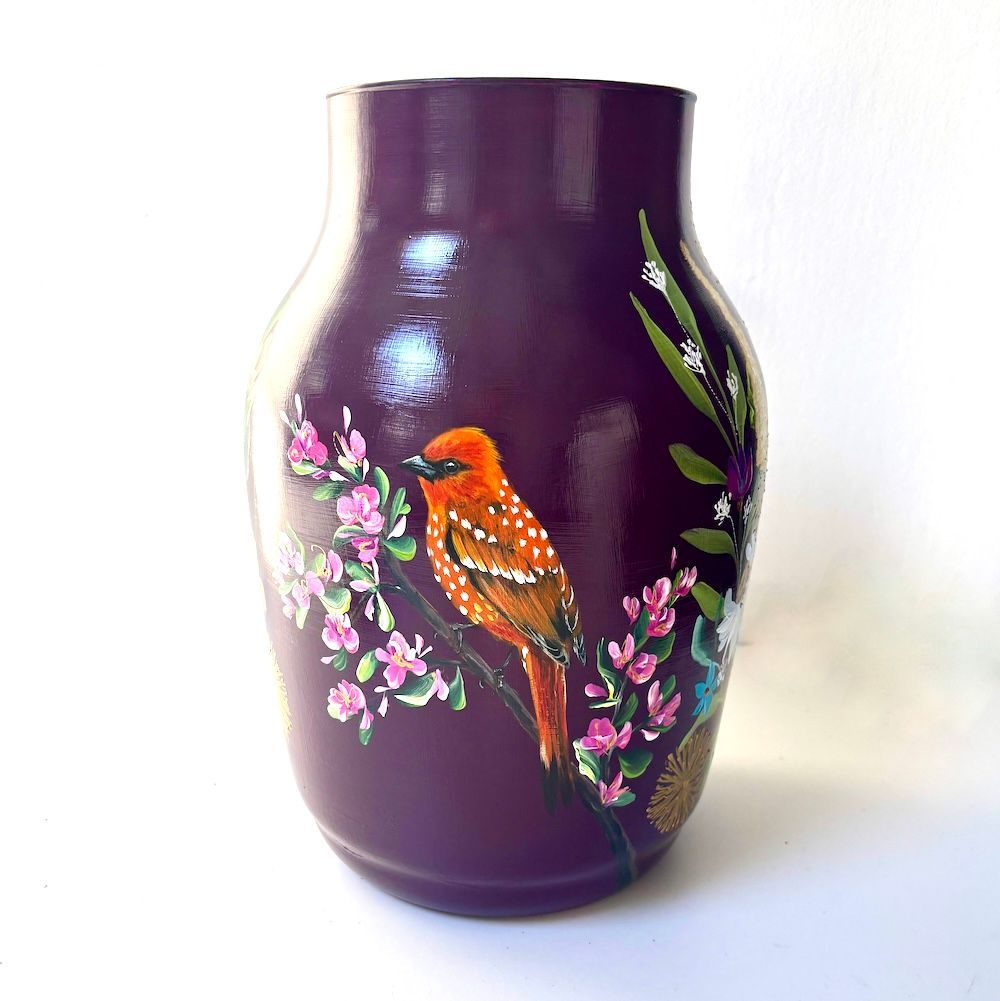 Paarse vaas met een beschilderde oranje vogel en roze bloesems