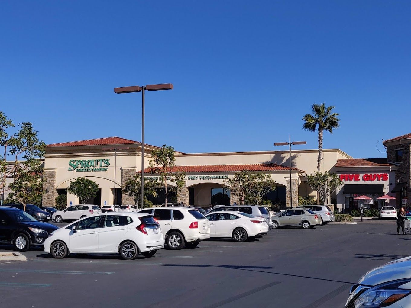 A lot of cars are parked in front of a grocery store.