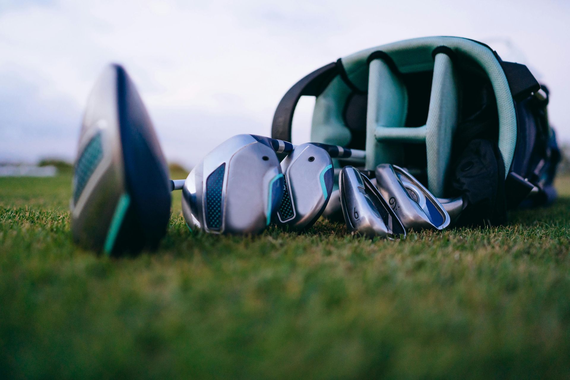 Golf clubs in a bag on green grass, ready for play.