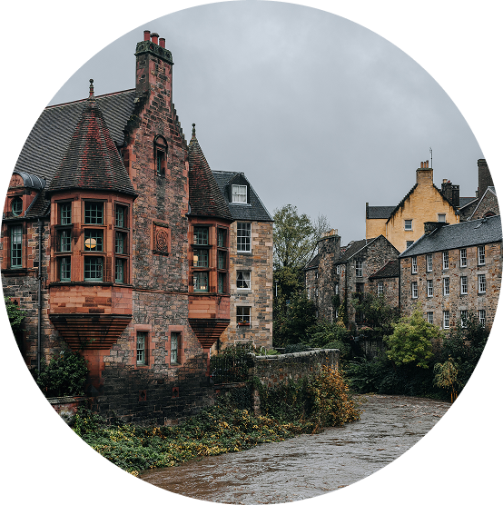 Historic brick houses along a cobblestone street under a cloudy sky