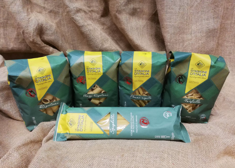 Su un tavolo è posato un gruppo di sacchetti di pasta.