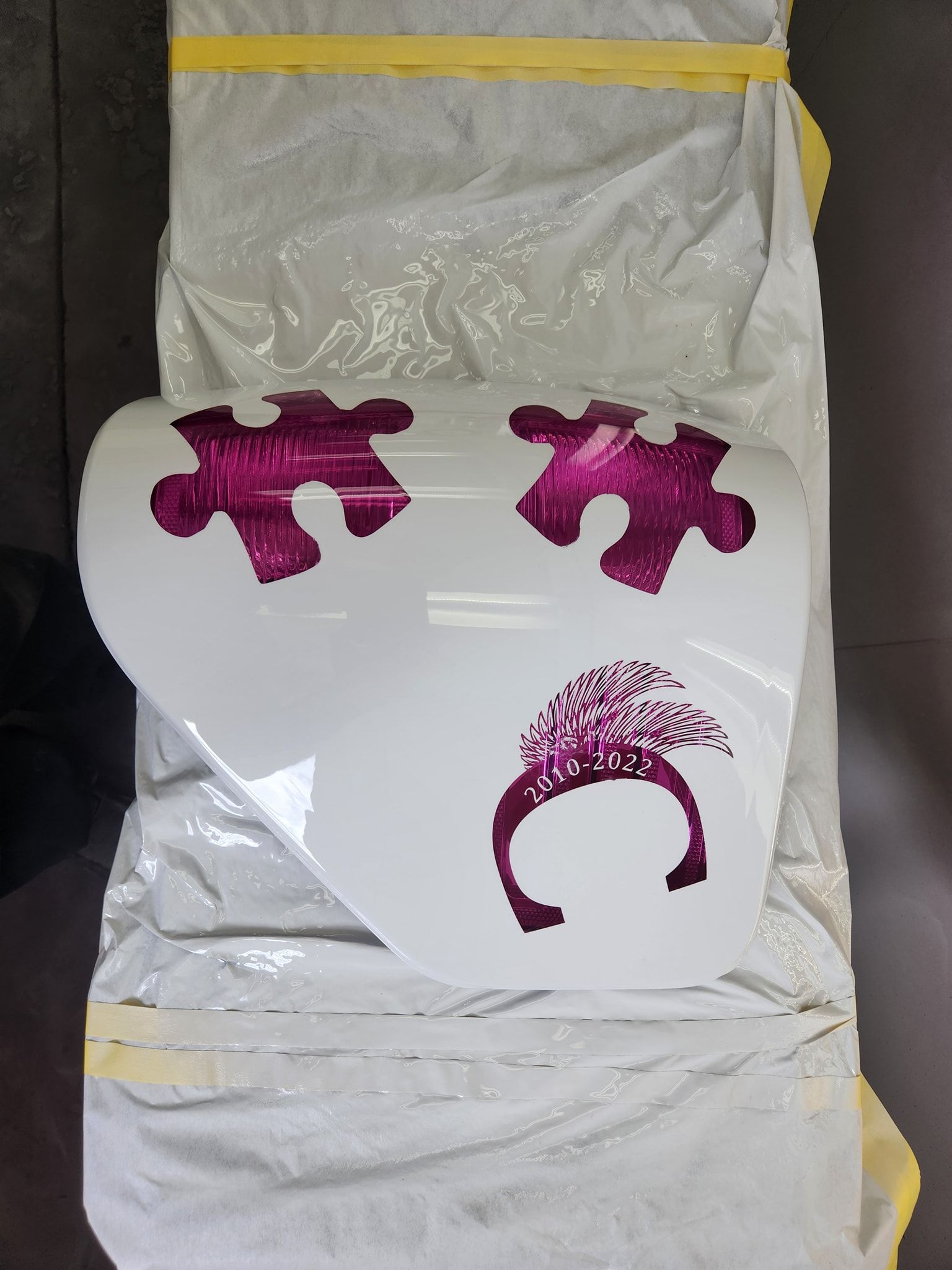White envelope with a pink heart-shaped puzzle design and a pink crescent moon graphic.