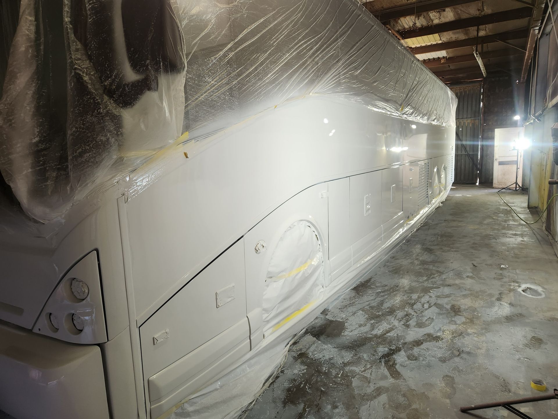 Wrapped bus parked inside a narrow garage hallway