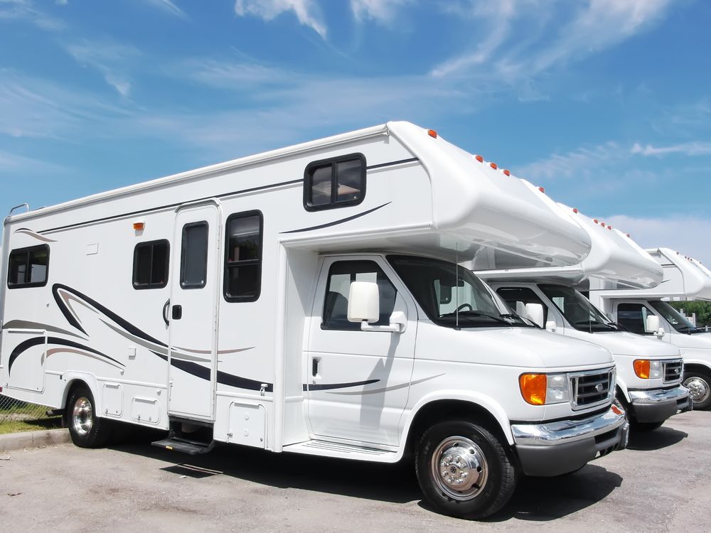 White RVs parked outdoors under a blue sky