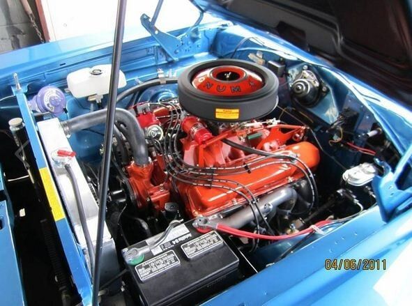 Classic car engine bay with bright red engine and blue bodywork shown from above