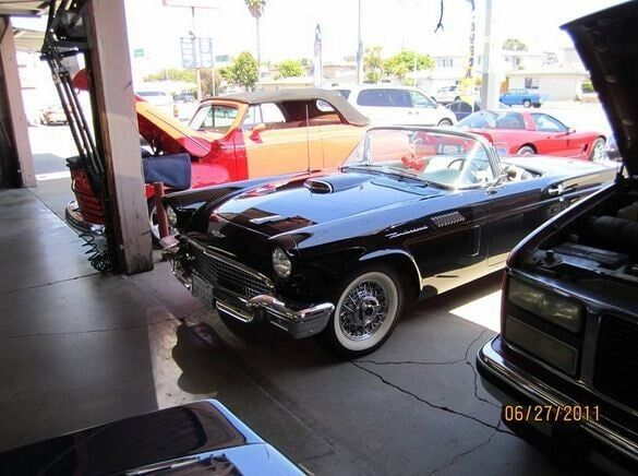 Classic black convertible car parked indoors among other vintage cars, dated 06/27/2011.