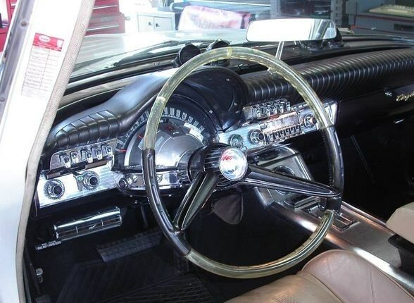 Classic car dashboard with chrome steering wheel and black interior controls