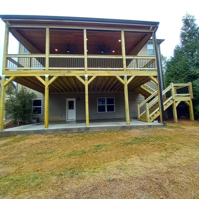 A two-story wooden deck addition with stairs, attached to a house with neutral siding.