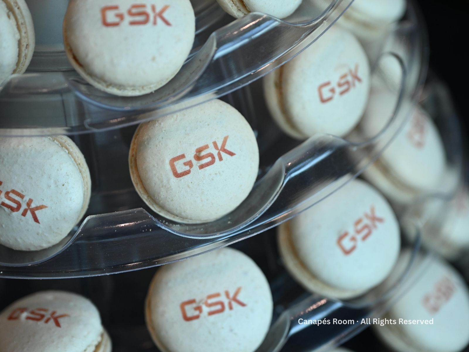 Macarons with the GSK logo stacked on a tiered display.