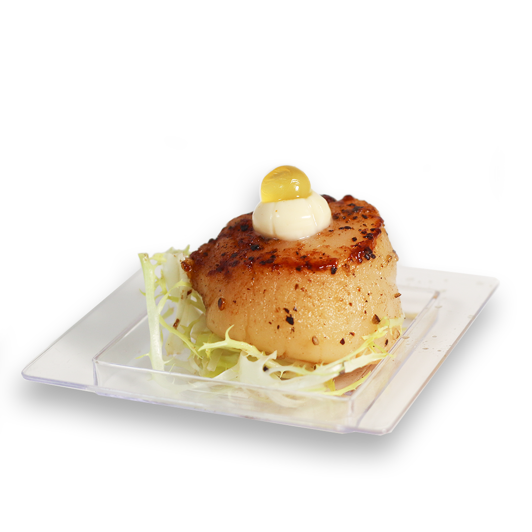 Seared scallop appetizer on a square plate with lettuce, topped with sauce and a yellow sphere.