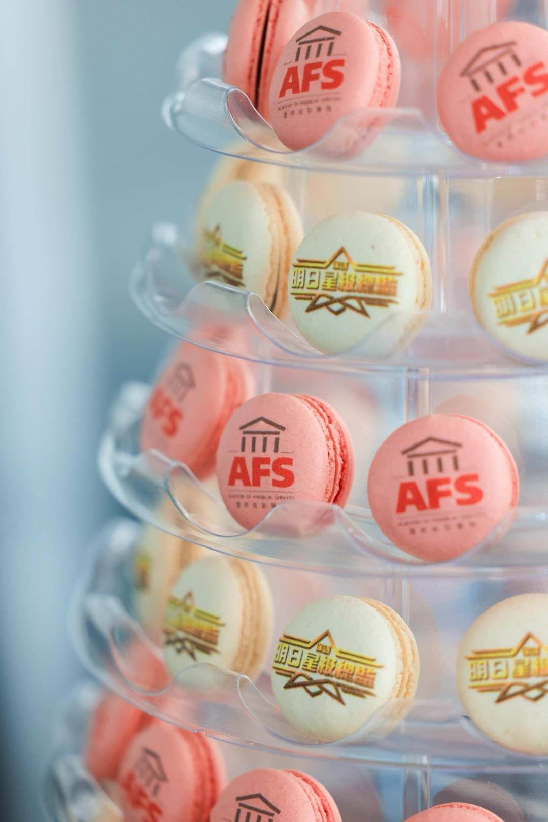 Macaron tower with AFS logo macarons. Pink and white macarons arranged on clear tiered stand.