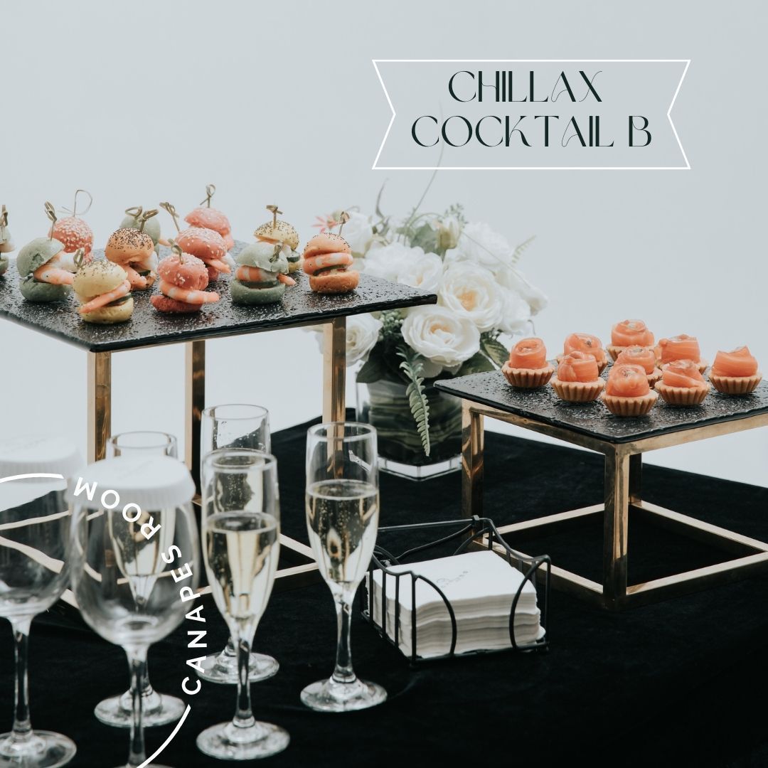 Buffet table with hors d'oeuvres on tiered platters, champagne flutes, napkins.