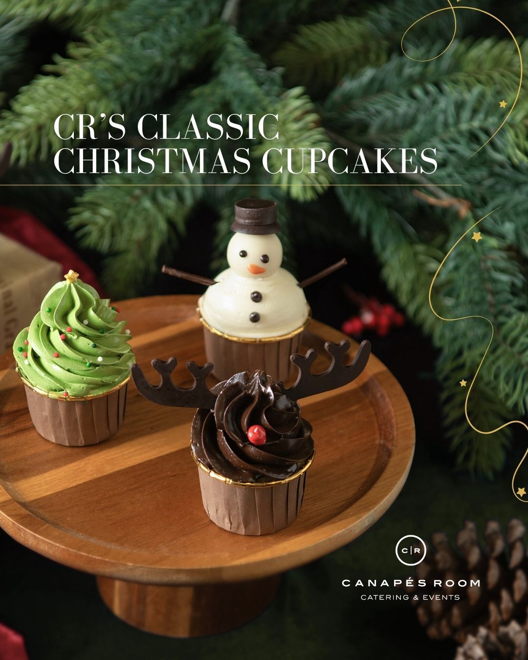 Christmas cupcakes on a wooden tray with festive decorations: green tree, snowman, and reindeer.