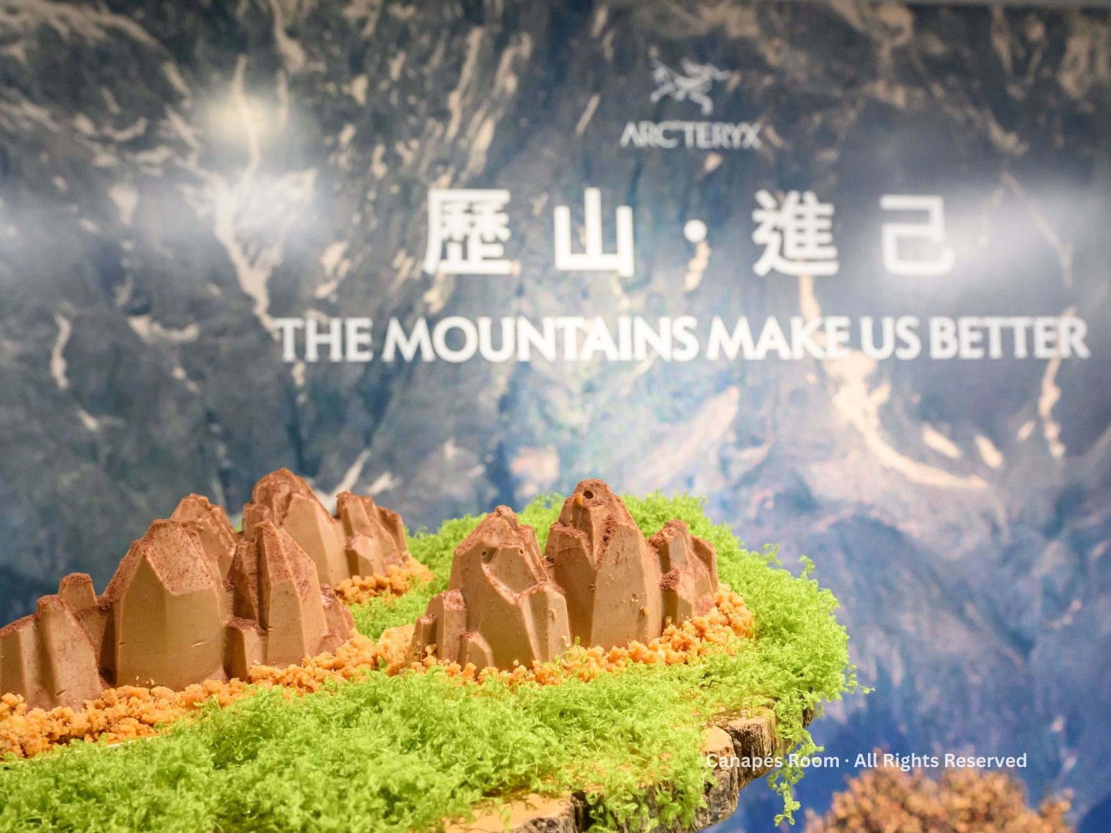 Mountains in front of a backdrop, Arc'teryx logo.