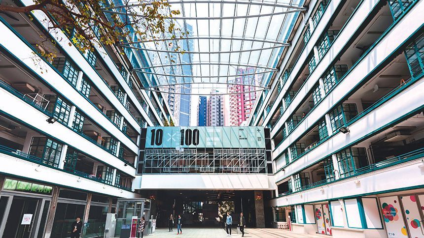 這是一棟多層建築的庭院內部景象，庭院頂部為玻璃屋頂。下方有人行走。
