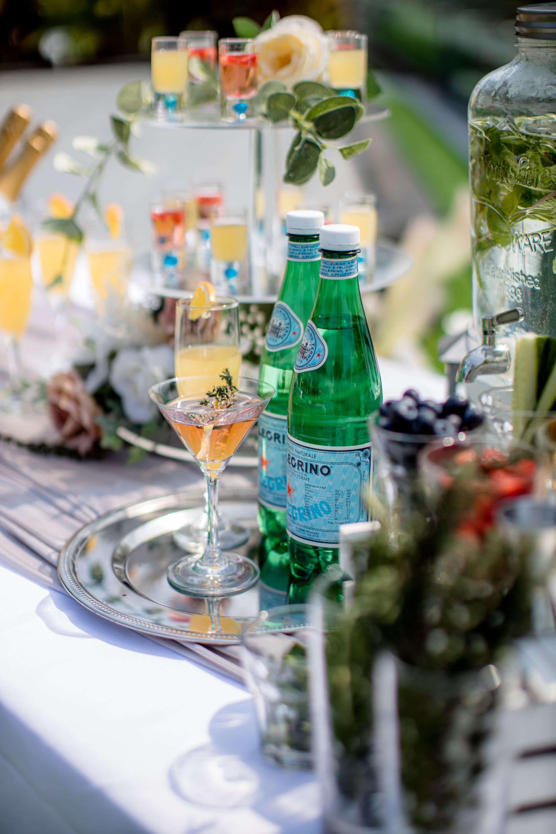 Cocktail bar setup with drinks and San Pellegrino bottles.