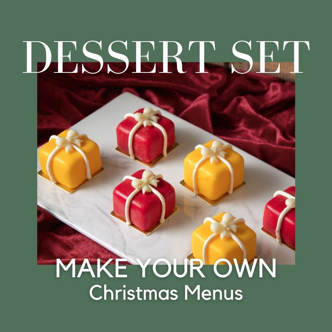 Dessert set of colorful present-shaped cakes on a white platter; text: 