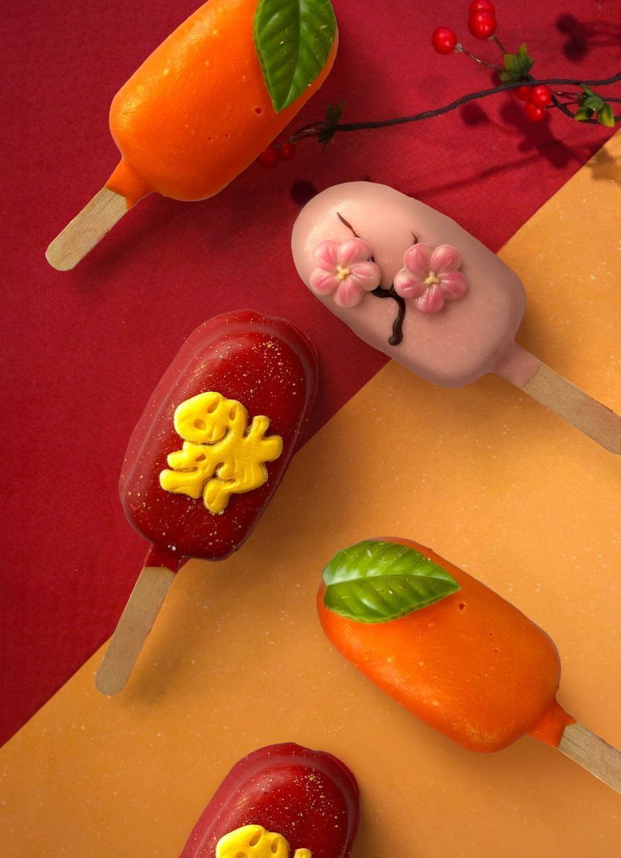 Cake pops on sticks decorated in red, pink, and orange, with festive designs on a red and orange background.