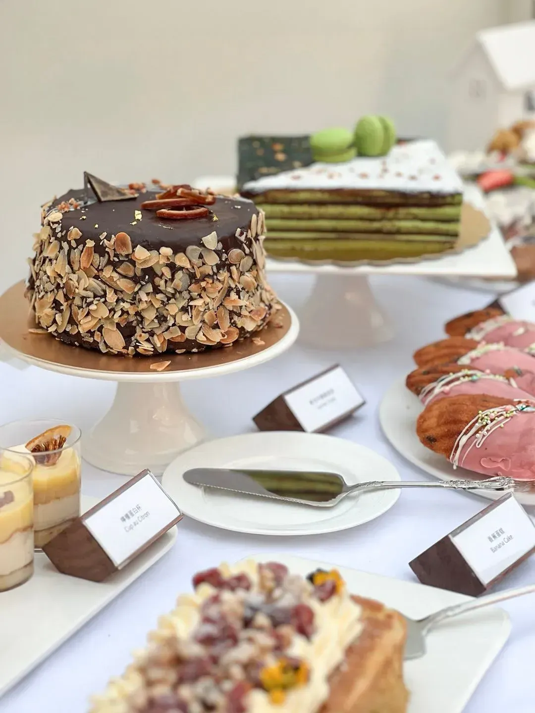 Dessert table with various cakes and pastries, including a chocolate cake and macarons.