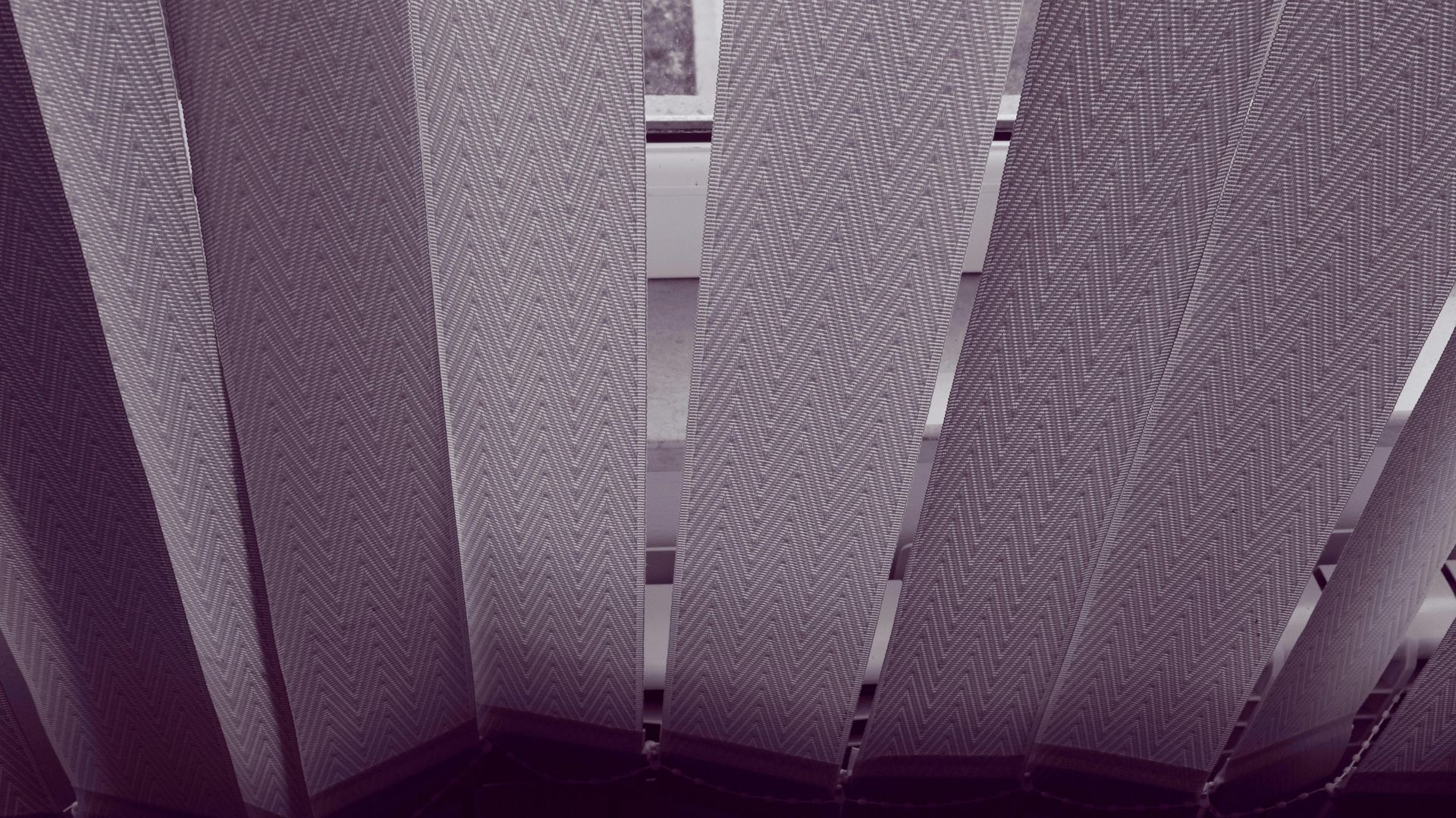Textured vertical fabric window blinds with chevron pattern for modern interior light control