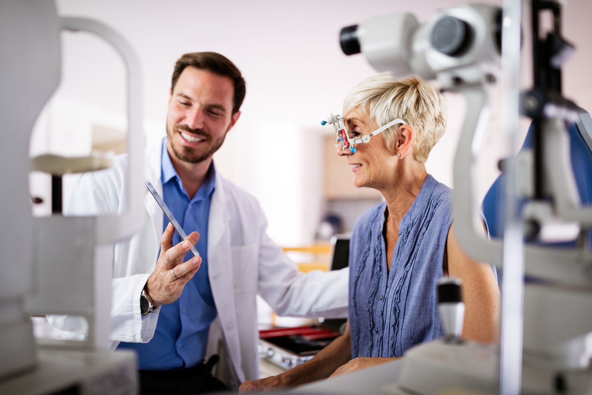 Two clinicians in white coats smiling and reviewing a patient’s results in a medical office