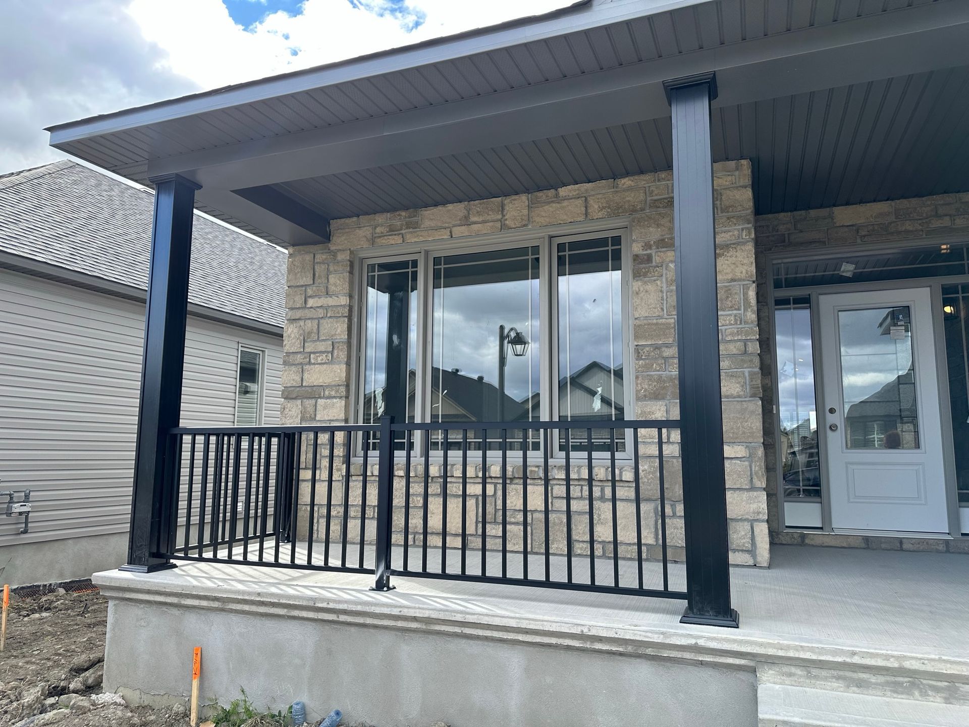 Une maison avec un porche et une balustrade noire