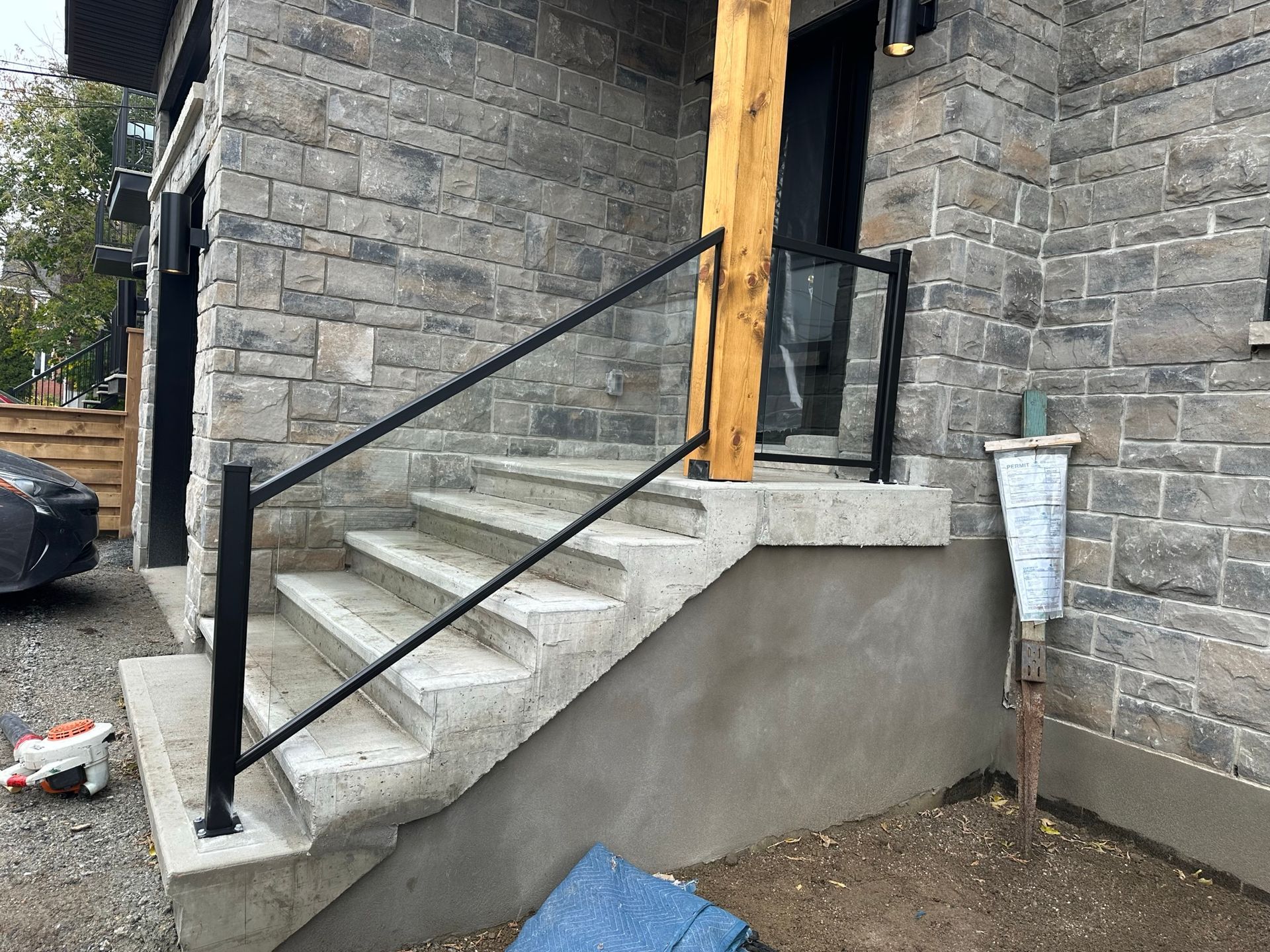 Un ensemble d'escaliers menant à un bâtiment en briques avec une rampe noire.