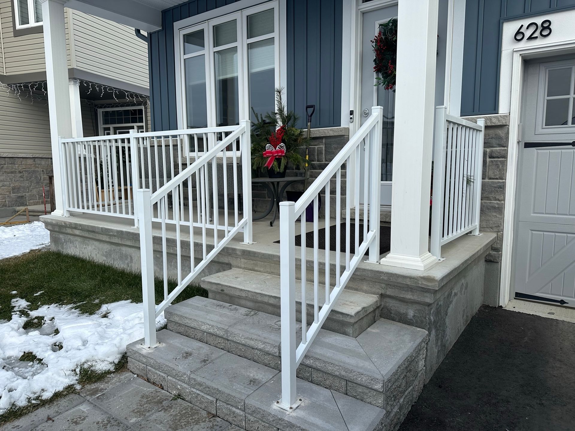 Le porche d'une maison avec une balustrade et des escaliers blancs.