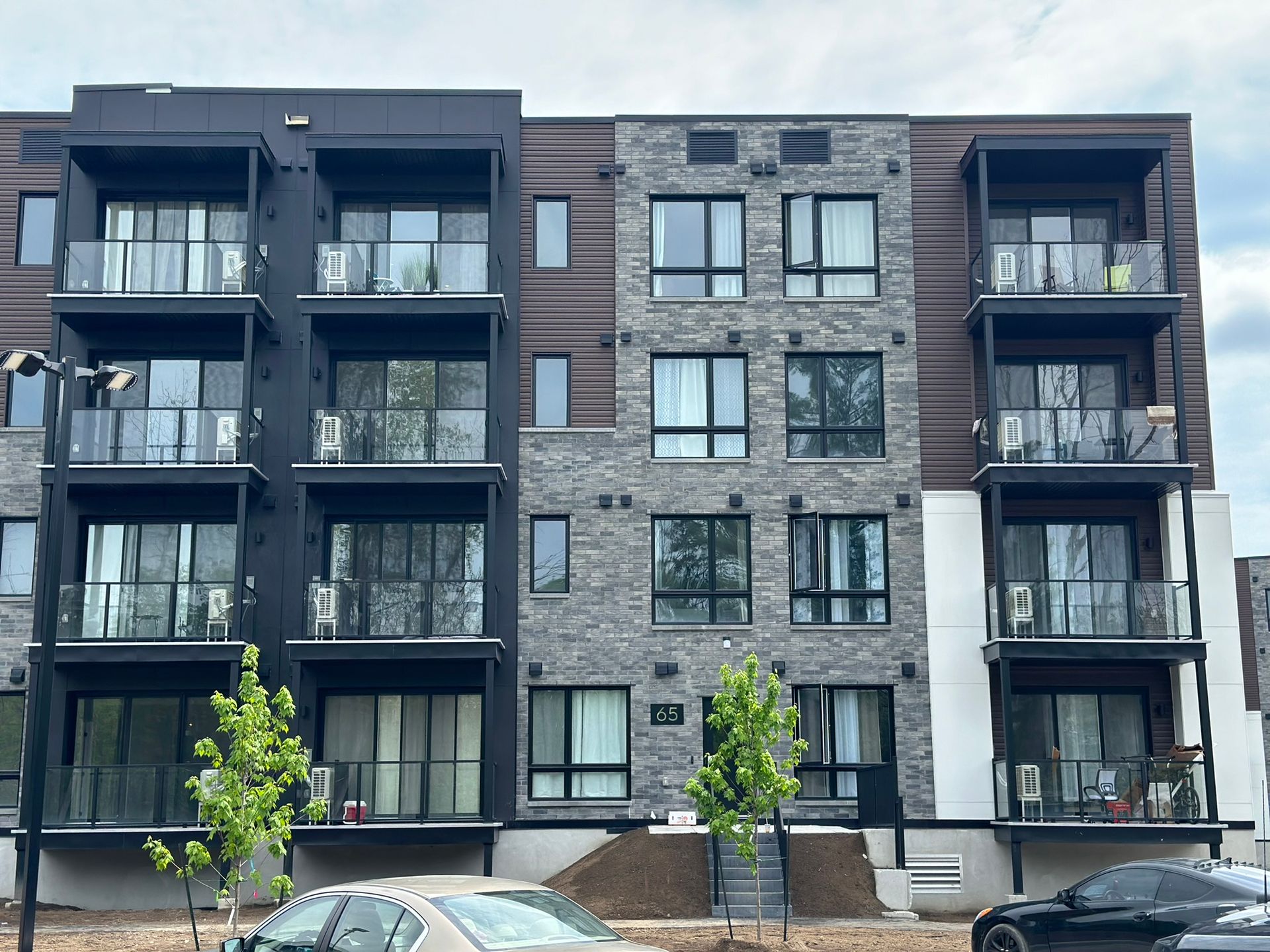 Un grand immeuble d'appartements avec des voitures garées devant