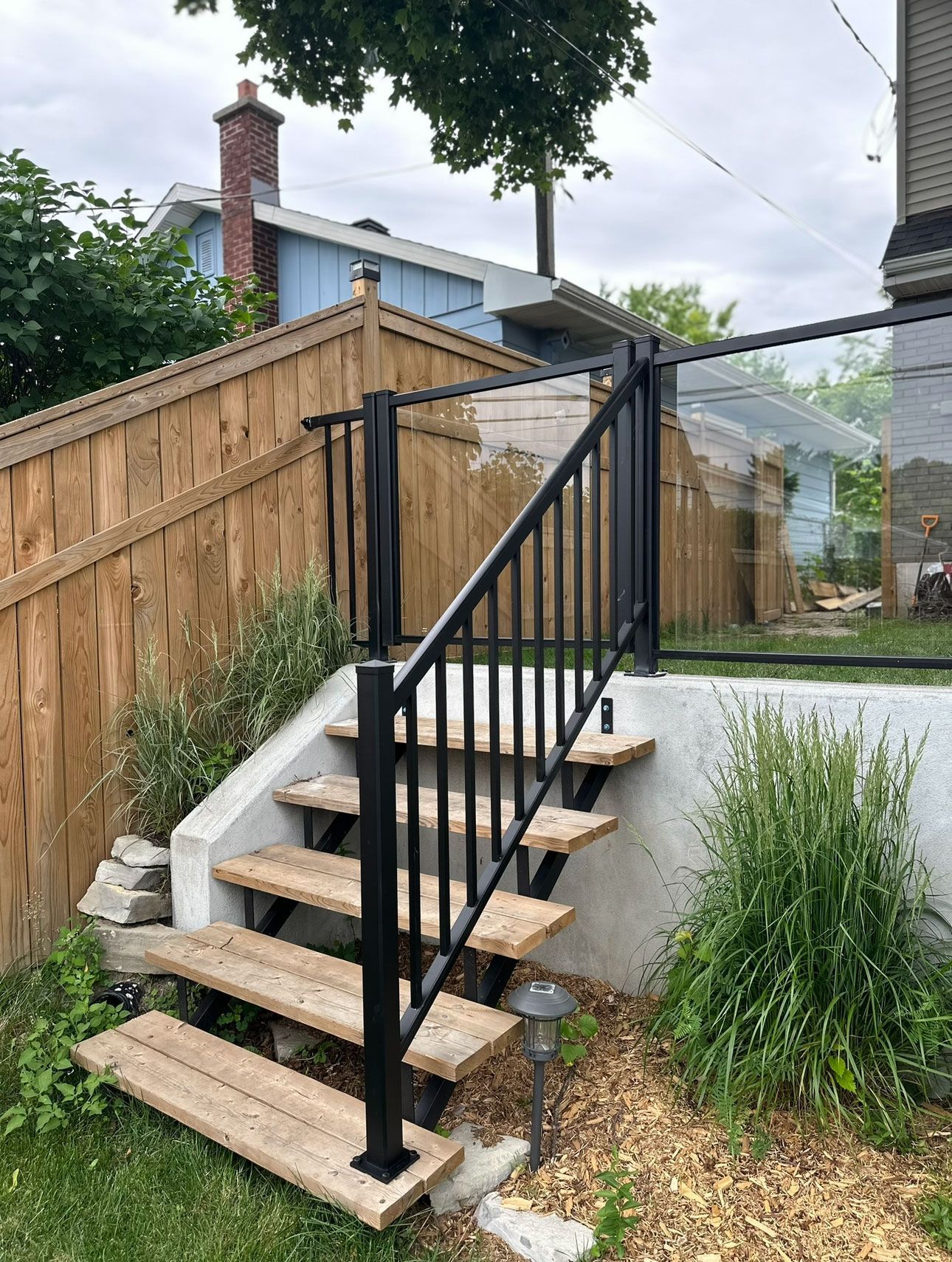 Un ensemble d'escaliers menant à une terrasse avec une balustrade en verre.