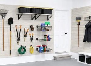 Garage wall with organized garden tools, shelves, and cleaning supplies mounted on white pegboard.
