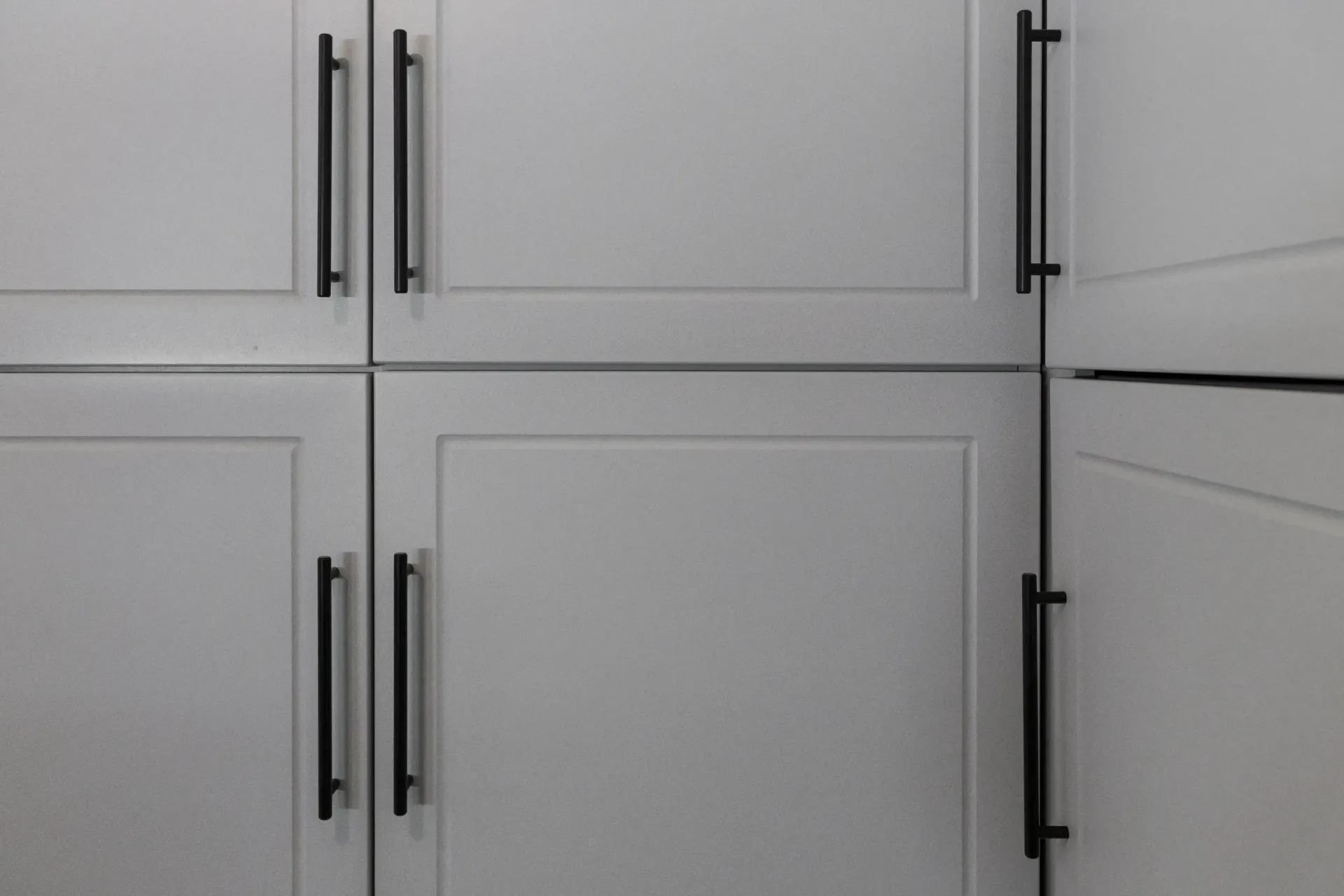 White cabinet doors with black handles in a kitchen-like setting
