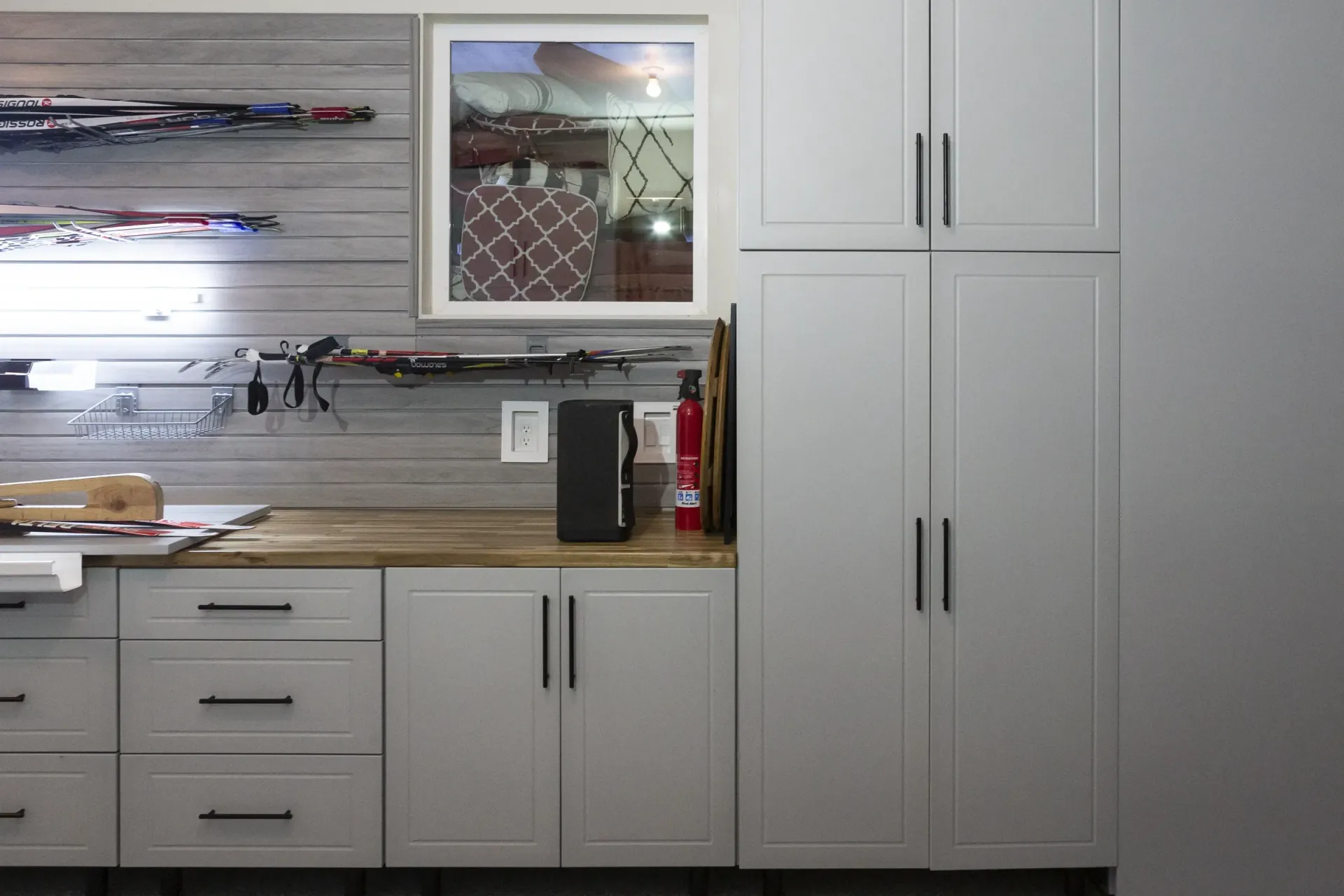 White kitchen cabinets and countertops with a window, drawers, and a coffee maker on the counter.
