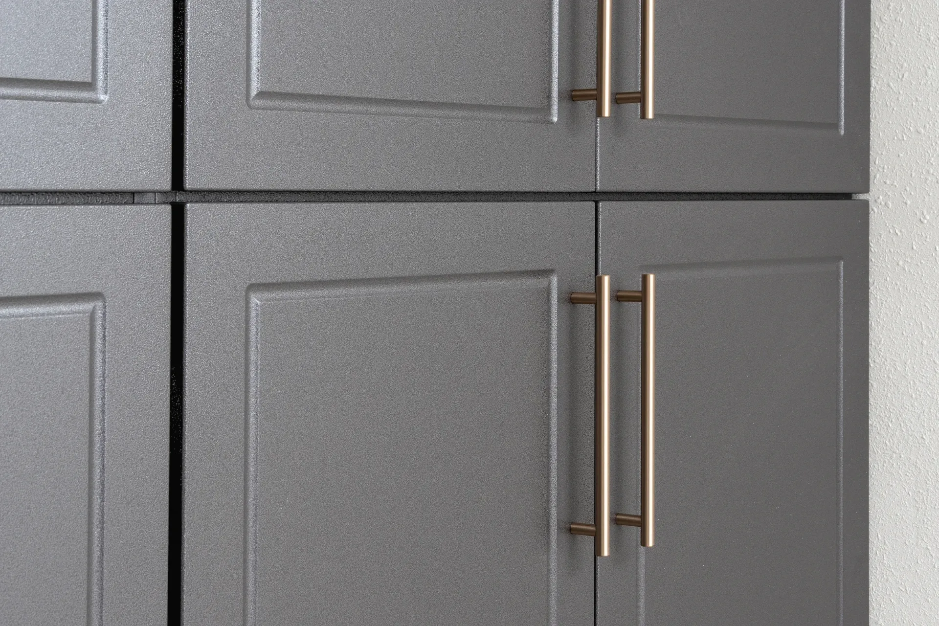 Close-up of gray cabinet doors with long bronze handles