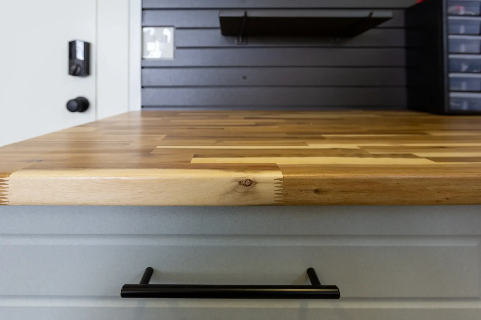 Wooden countertop with black drawer handle in a modern kitchen or workspace